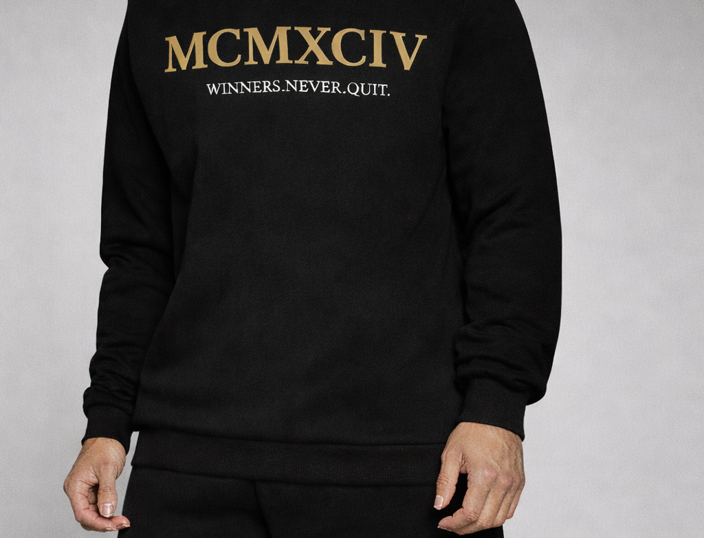 Black sweatshirt and shorts set with gold text and logo on a gray background